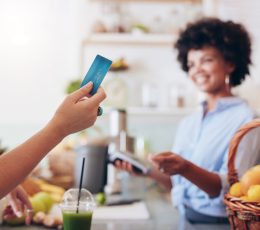a woman holding a credit card in a kitchen.